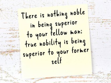 Sarı yapışkan not, ahşap duvarda el yazısıyla yazılmış zekice bir alıntıyla.