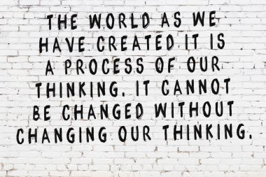 Üzerinde mantıklı alıntıların yazılı olduğu siyah boyanmış beyaz tuğla duvar.