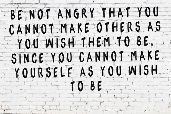 Üzerinde mantıklı alıntıların yazılı olduğu siyah boyanmış beyaz tuğla duvar.