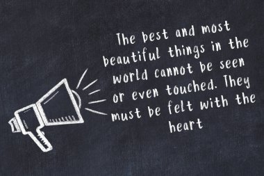 Bir hoparlörün tebeşir çizimi ve siyah karatahtaya el yazısıyla yazılmış alıntılar