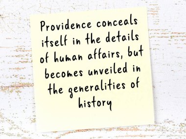 Tahta duvarda asılı sarı yapışkan nota elle yazılmış bilgece bir alıntı.