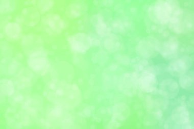 Çember şeklindeki bokeh noktalarıyla açık yeşil soyut odaklanmış arkaplan