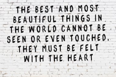 Beyaz tuğla duvar ve bilgece alıntıların yazılı olduğu siyah yazı.