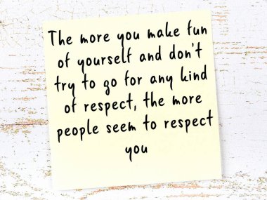 Sarı yapışkan not, ahşap duvarda el yazısıyla yazılmış zekice bir alıntıyla.