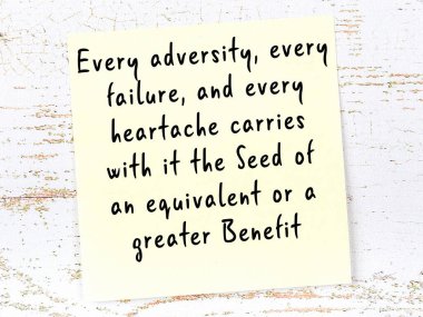 Sarı yapışkan not, ahşap duvarda el yazısıyla yazılmış zekice bir alıntıyla.