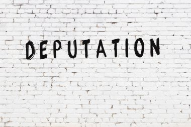 Yazı uyarlaması beyaz tuğla duvara siyah boya ile yazılmış.