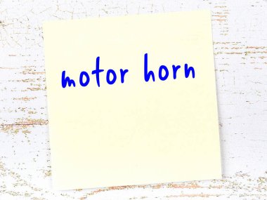 Motor kornasını hatırlatma kavramı. Tahta duvarda üzerinde yazı olan sarı yapışkan kağıt.