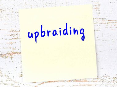 Tahta duvarda sarı yapışkan bir not, el yazısıyla yazılmış.