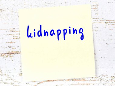 Kaçırılmayla ilgili hatırlatma kavramı. Tahta duvarda üzerinde yazı olan sarı yapışkan kağıt.