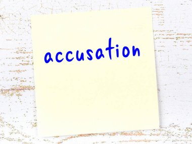 Tahta duvardaki sarı yapışkan notta elle yazılmış suçlama var.