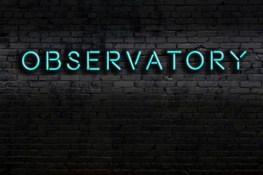 Duvarda yazıt gözlemevi olan neon tabela. Gece görünümü