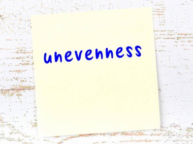 Eşitsizliği hatırlatma kavramı. Tahta duvarda üzerinde yazı olan sarı yapışkan kağıt.