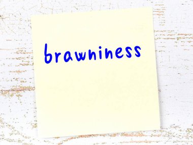 Tahta duvardaki sarı yapışkan notada el yazısıyla yazılmış kas gücü.