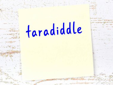 Tahta duvarda el yazısıyla yazılmış sarı yapışkan bir not var.