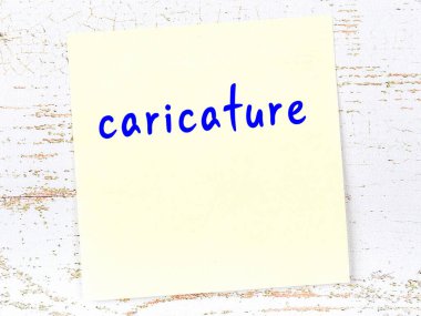 Tahta duvardaki sarı yapışkan notta el yazısıyla yazılmış karikatür var.