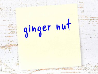 Tahta duvardaki sarı yapışkan notta el yazısıyla yazılmış kızıl fındık.