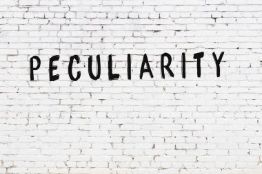 Üzerinde siyah boya bulunan beyaz tuğlalı bir duvar.