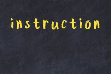 Tebeşir el yazısıyla yazılmış yazı talimatı siyah masada.