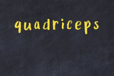 Tebeşir el yazısıyla yazılmış kuadriseps siyah masada.