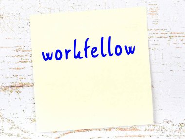 İş arkadaşını hatırlatma kavramı. Tahta duvarda üzerinde yazı olan sarı yapışkan kağıt.