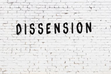 Yazı anlaşmazlığı beyaz tuğla duvara siyah boya ile yazılmış..