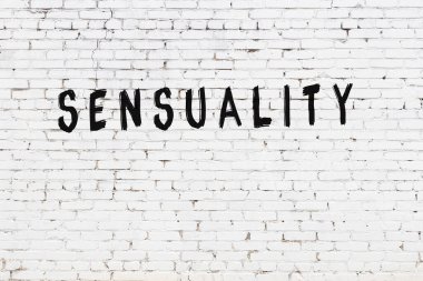 Beyaz tuğla duvara siyah boya ile yazılmış şehvet yazıları..