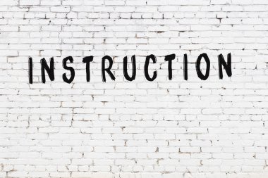 Siyah boyayla el yazısıyla yazılmış beyaz tuğla duvar.