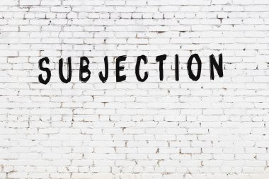 Yazı, beyaz tuğla duvara siyah boya ile yazılmış..