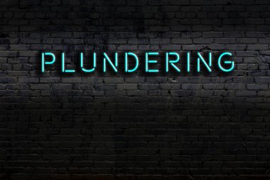 Duvara yazı kazınmış neon levhası. Gece görünümü