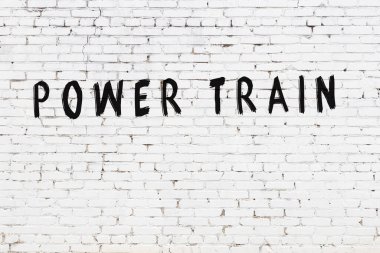 Beyaz tuğladan bir duvar ve siyah boyalı el yazısıyla yazılmış güç treni.