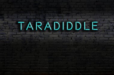 Üzerinde yazı olan neon tabela tuğla duvara yaslanmış. Gece görünümü