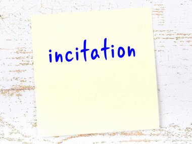 Kışkırtma hakkında hatırlatma kavramı. Tahta duvarda üzerinde yazı olan sarı yapışkan kağıt.