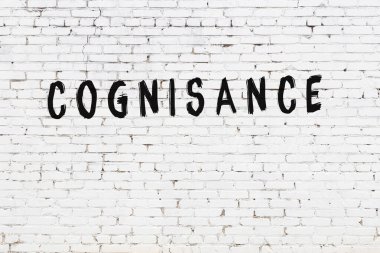 Üzerinde siyah boya bulunan beyaz tuğladan bir duvar.