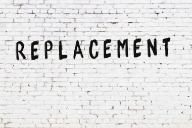 Beyaz tuğla duvara siyah boya ile yazılan yazıtlar.