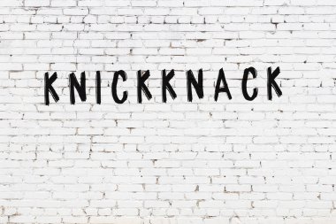 Beyaz tuğla duvara siyah boya ile yazılmış yazıtlar..