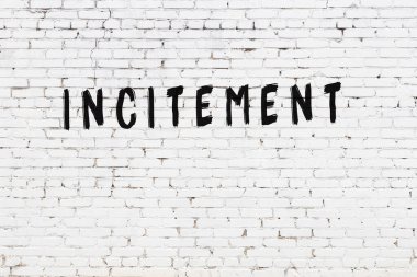 Yazı, beyaz tuğla duvara siyah boya ile yazıldı..