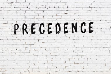 Yazı önceliği beyaz tuğla duvara siyah boya ile yazılmış..