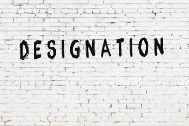 Beyaz tuğlalı duvar. Üzerinde siyah boya yazılı.