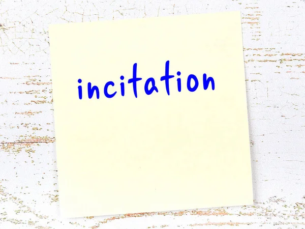 Kışkırtma hakkında hatırlatma kavramı. Tahta duvarda üzerinde yazı olan sarı yapışkan kağıt.