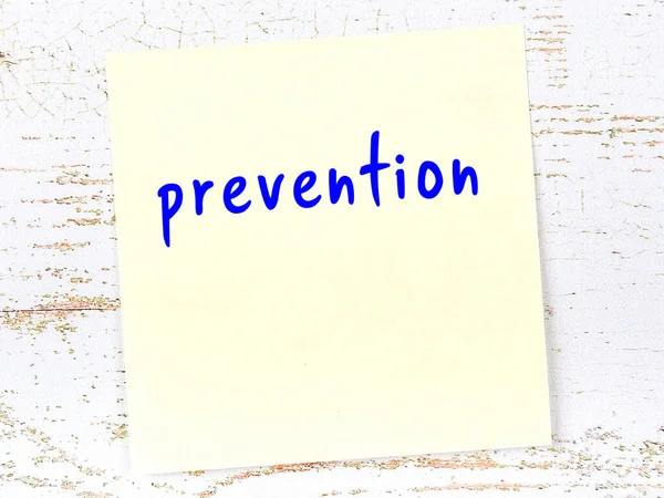 Önlemeyle ilgili hatırlatma kavramı. Tahta duvarda üzerinde yazı olan sarı yapışkan kağıt.