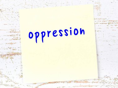 Tahta duvardaki sarı yapışkan notta el yazısı baskı var.