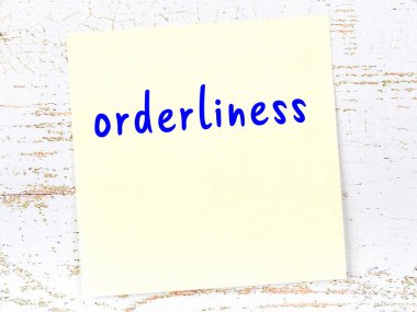 Düzeni hatırlatma kavramı. Tahta duvarda üzerinde yazı olan sarı yapışkan kağıt.