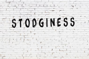 Beyaz tuğlalı duvar, siyah boyayla yazılmış.