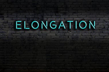 Tuğla duvara asılmış neon levhası. Gece görünümü