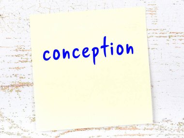 Hamileliği hatırlatma kavramı. Tahta duvarda üzerinde yazı olan sarı yapışkan kağıt.