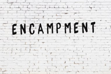 Üzerinde siyah boya bulunan beyaz tuğladan bir duvar.