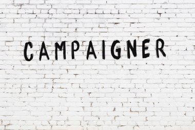 Beyaz tuğla duvara siyah boya ile yazılmış bir yazıt kampanyacısı..