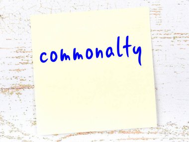 Tahta duvarda el yazısıyla yazılmış sarı yapışkan bir not var.