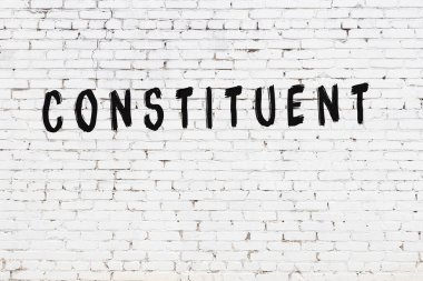 Beyaz tuğladan duvar, siyah boyayla el yazısıyla yazılmış.