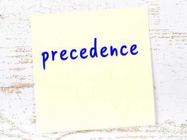 Tahta duvardaki sarı yapışkan notta el yazısı önceliği var.